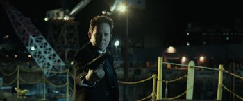 Movie still from “John Wick” (2014), directed by Chad Stahelski – A man in a black suit holding a gun; Close Up shot, High angle