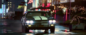 Movie still from “John Wick: Chapter 2” (2017), directed by Chad Stahelski – A car is driving down the street at night; Wide shot, Low angle