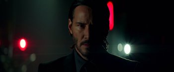 Movie still from “John Wick: Chapter 2” (2017), directed by Chad Stahelski – A man in a suit and tie with long black hair; Close Up shot, Low angle