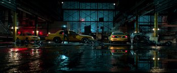 Movie still from “John Wick: Chapter 2” (2017), directed by Chad Stahelski – Two yellow taxis are parked in a parking garage; Extreme Wide shot, High angle