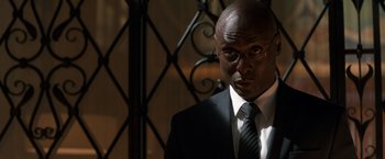 Movie still from “John Wick: Chapter 2” (2017), directed by Chad Stahelski – A man in a suit and tie standing in front of a metal gate; Close Up shot, Low angle