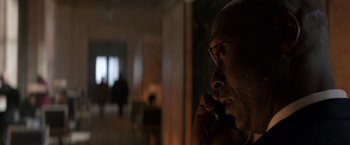 Movie still from “John Wick: Chapter 2” (2017), directed by Chad Stahelski – A man talking on a phone in a dark room; Close Up shot, Over the shoulder angle
