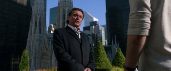 Movie still from “John Wick: Chapter 2” (2017), directed by Chad Stahelski – A man standing in front of a city skyline; Medium shot, Low angle