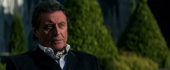 Movie still from “John Wick: Chapter 2” (2017), directed by Chad Stahelski – An older man wearing a suit and a bow tie; Close Up shot, Low angle