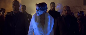 Movie still from “John Wick: Chapter 2” (2017), directed by Chad Stahelski – A woman in a white coat standing next to two men; Medium shot, Low angle