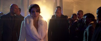 Movie still from “John Wick: Chapter 2” (2017), directed by Chad Stahelski – A woman in a white fur coat standing next to a man; Medium shot, Over the shoulder angle