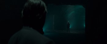 Movie still from “John Wick: Chapter 2” (2017), directed by Chad Stahelski – A man standing in the dark in front of a cave; Wide shot, Over the shoulder angle