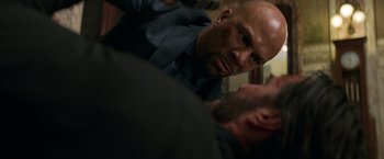Movie still from “John Wick: Chapter 2” (2017), directed by Chad Stahelski – A bald man in a black shirt is looking at another bald man; Close Up shot, Over the shoulder angle