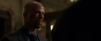 Movie still from “John Wick: Chapter 2” (2017), directed by Chad Stahelski – A bald man wearing a black shirt and a tie; Close Up shot, Over the shoulder angle