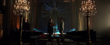 Movie still from “John Wick: Chapter 2” (2017), directed by Chad Stahelski – Two men standing in front of a large statue of the virgin mary; Wide shot, Over the shoulder angle