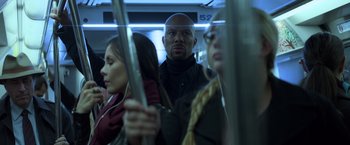Movie still from “John Wick: Chapter 2” (2017), directed by Chad Stahelski – A group of people riding on a train together; Close Up shot, Over the shoulder angle