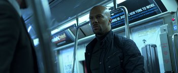 Movie still from “John Wick: Chapter 2” (2017), directed by Chad Stahelski – A man standing on a train looking into the distance; Close Up shot, Low angle