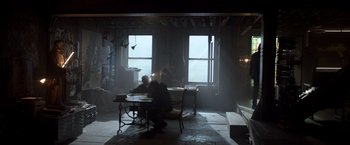 Movie still from “John Wick: Chapter 2” (2017), directed by Chad Stahelski – Two people sitting at a table in a room; Wide shot, Low angle