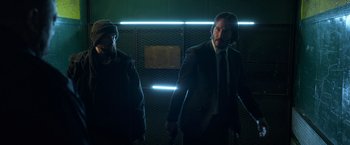 Movie still from “John Wick: Chapter 2” (2017), directed by Chad Stahelski – A man in a suit and tie next to another man in a jacket and tie; Medium shot, Low angle