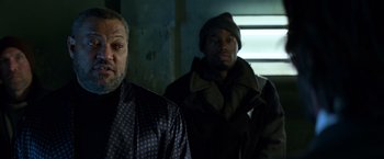 Movie still from “John Wick: Chapter 2” (2017), directed by Chad Stahelski – Two men standing next to each other in a dark room; Medium shot, Low angle