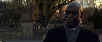 Movie still from “John Wick: Chapter 2” (2017), directed by Chad Stahelski – A person wearing glasses and a coat; Close Up shot, Over the shoulder angle