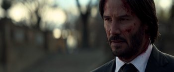 Movie still from “John Wick: Chapter 2” (2017), directed by Chad Stahelski – A person wearing a suit and tie; Close Up shot, Over the shoulder angle