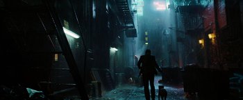 Movie still from “John Wick: Chapter 3 - Parabellum” (2019), directed by Chad Stahelski – A man and a dog walking down a street at night in the rain; Wide shot, Low angle