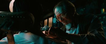 Movie still from “John Wick: Chapter 3 - Parabellum” (2019), directed by Chad Stahelski – An older man writing on a piece of paper; Close Up shot, Over the shoulder angle