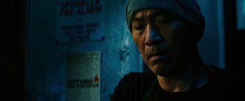 Movie still from “John Wick: Chapter 3 - Parabellum” (2019), directed by Chad Stahelski – A man in a blue hat is looking down; Close Up shot, Low angle