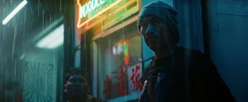 Movie still from “John Wick: Chapter 3 - Parabellum” (2019), directed by Chad Stahelski – A man with a head covering standing in front of a store; Medium shot, Low angle