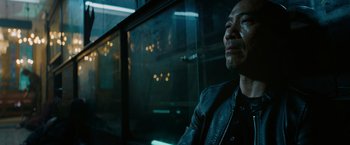 Movie still from “John Wick: Chapter 3 - Parabellum” (2019), directed by Chad Stahelski – A man sitting in front of a glass window; Close Up shot, Low angle