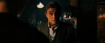 Movie still from “John Wick: Chapter 3 - Parabellum” (2019), directed by Chad Stahelski – A man in a suit and tie in a dimly - lit room; Close Up shot, Over the shoulder angle