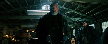 Movie still from “John Wick: Chapter 3 - Parabellum” (2019), directed by Chad Stahelski – An older man with a gray beard wearing a black jacket; Medium shot, Low angle