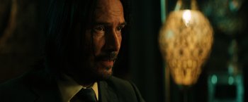 Movie still from “John Wick: Chapter 3 - Parabellum” (2019), directed by Chad Stahelski – A person wearing a suit and tie; Close Up shot, Over the shoulder angle