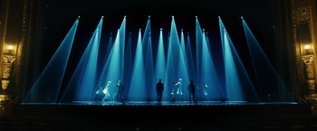 Movie still from “John Wick: Chapter 3 - Parabellum” (2019), directed by Chad Stahelski – A group of people standing in front of a bunch of lights on a stage; Extreme Wide shot, Low angle