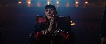 Movie still from “John Wick: Chapter 3 - Parabellum” (2019), directed by Chad Stahelski – An older woman sitting in a chair with her hands clasped together; Close Up shot, Low angle