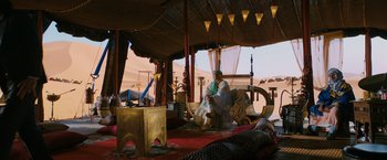 Movie still from “John Wick: Chapter 3 - Parabellum” (2019), directed by Chad Stahelski – A man sitting on a chair in a tent; Wide shot, High angle