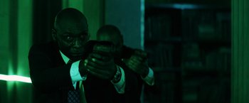 Movie still from “John Wick: Chapter 3 - Parabellum” (2019), directed by Chad Stahelski – A man holding a cell phone in his hands; Medium shot, Low angle