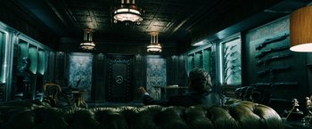 Movie still from “John Wick: Chapter 3 - Parabellum” (2019), directed by Chad Stahelski – A person sitting on a couch in a room; Wide shot, Low angle