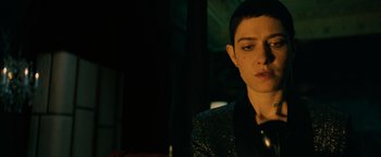 Movie still from “John Wick: Chapter 3 - Parabellum” (2019), directed by Chad Stahelski – A woman with short hair is looking down at her phone; Close Up shot, Low angle