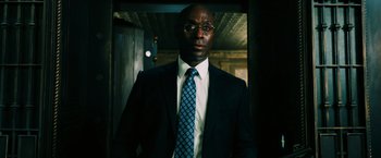 Movie still from “John Wick: Chapter 3 - Parabellum” (2019), directed by Chad Stahelski – A man in a suit and tie standing in front of a wall; Close Up shot, Low angle