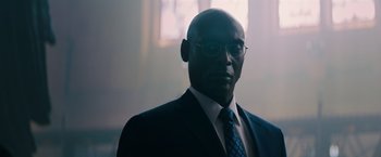 Movie still from “John Wick: Chapter 3 - Parabellum” (2019), directed by Chad Stahelski – A man in a suit and tie with glasses; Close Up shot, Low angle