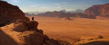 Movie still from “John Wick: Chapter 4” (2023), directed by Chad Stahelski – A person standing on top of a cliff in the desert; Extreme Wide shot, High angle