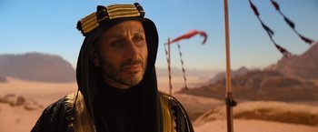 Movie still from “John Wick: Chapter 4” (2023), directed by Chad Stahelski – A man in a costume standing in the desert; Close Up shot, Over the shoulder angle