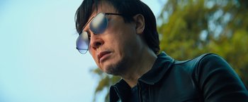 Movie still from “John Wick: Chapter 4” (2023), directed by Chad Stahelski – A person wearing sunglasses; Close Up shot, Low angle