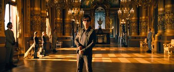 Movie still from “John Wick: Chapter 4” (2023), directed by Chad Stahelski – A man standing in an ornate room with a cane; Wide shot, Low angle