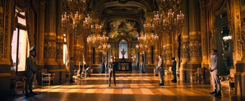 Movie still from “John Wick: Chapter 4” (2023), directed by Chad Stahelski – A group of people standing inside of a large room; Extreme Wide shot, Low angle