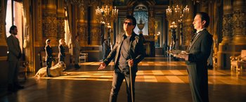 Movie still from “John Wick: Chapter 4” (2023), directed by Chad Stahelski – A man holding a cane in a large room; Wide shot, Low angle
