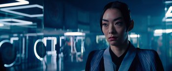 Movie still from “John Wick: Chapter 4” (2023), directed by Chad Stahelski – A young asian woman standing in a dark room; Close Up shot, Over the shoulder angle