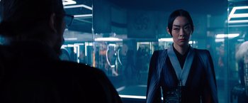 Movie still from “John Wick: Chapter 4” (2023), directed by Chad Stahelski – A woman standing in front of a glass wall; Medium shot, Over the shoulder angle