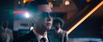 Movie still from “John Wick: Chapter 4” (2023), directed by Chad Stahelski – A person wearing a suit and sunglasses; Close Up shot, Low angle