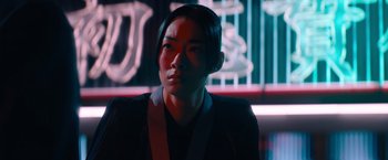 Movie still from “John Wick: Chapter 4” (2023), directed by Chad Stahelski – A woman in a black jacket is standing in a dark room; Close Up shot, Low angle