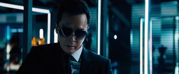 Movie still from “John Wick: Chapter 4” (2023), directed by Chad Stahelski – A man in a suit and sunglasses looking down; Close Up shot, Low angle