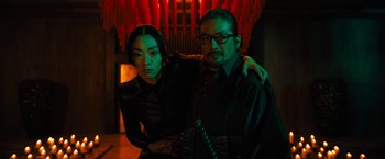 Movie still from “John Wick: Chapter 4” (2023), directed by Chad Stahelski – A man and a woman posing for a picture; Medium shot, Low angle