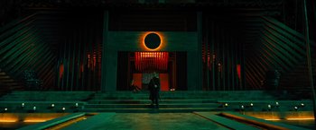 Movie still from “John Wick: Chapter 4” (2023), directed by Chad Stahelski – A man standing in front of an entrance to a building; Extreme Wide shot, Low angle